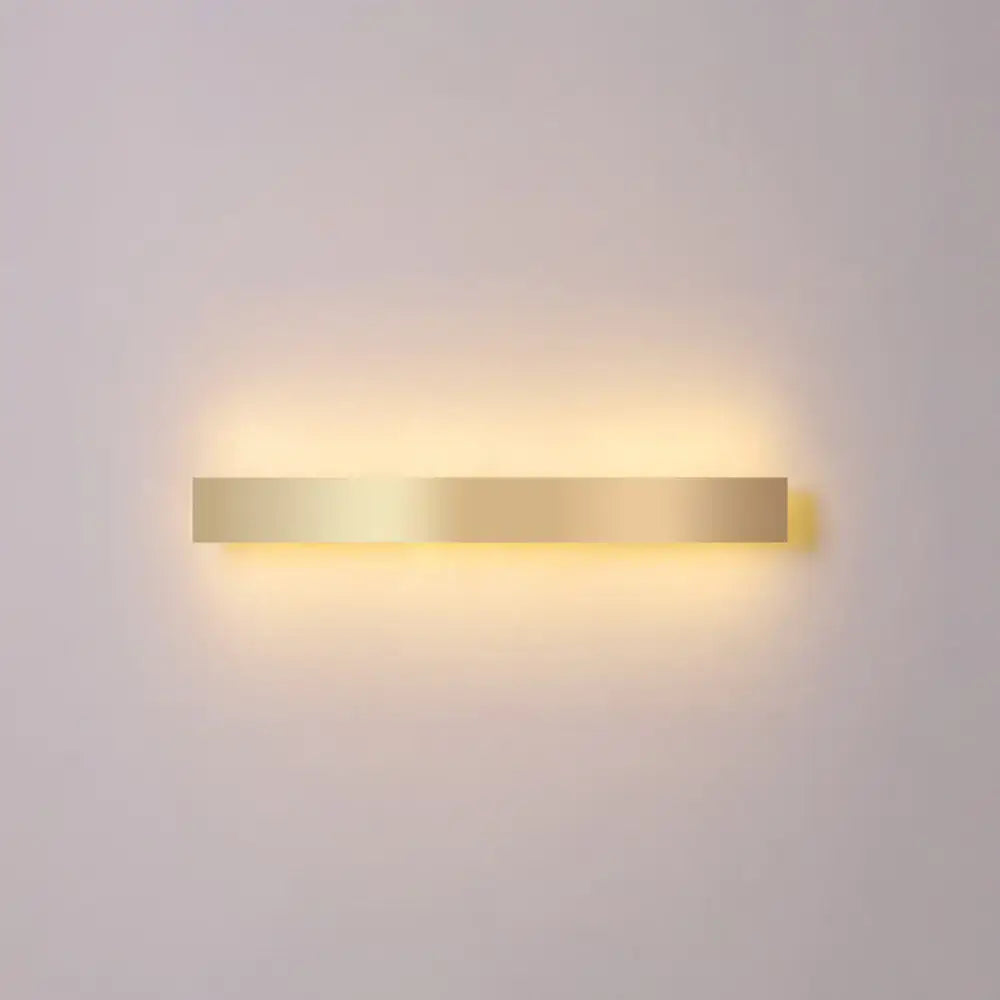 A sleek rectangular minimalist gold plated led wall sconce with gold toned finish for living room or bar lighting