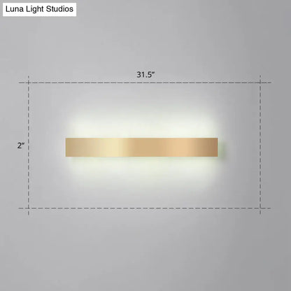 A sleek minimalist gold plated led wall sconce with a rectangular design for living room or bar lighting