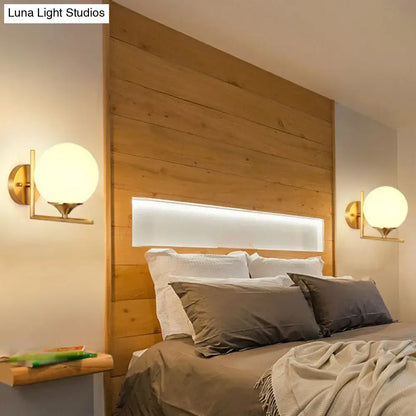 Minimalist gold sphere wall mounted light with frosted glass globe shades in gold finish for bedroom use