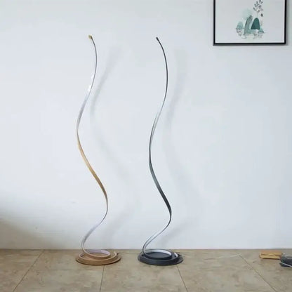 Two elegant minimalist standing lamps with metallic finishes in brushed silver and matte black on circular bases