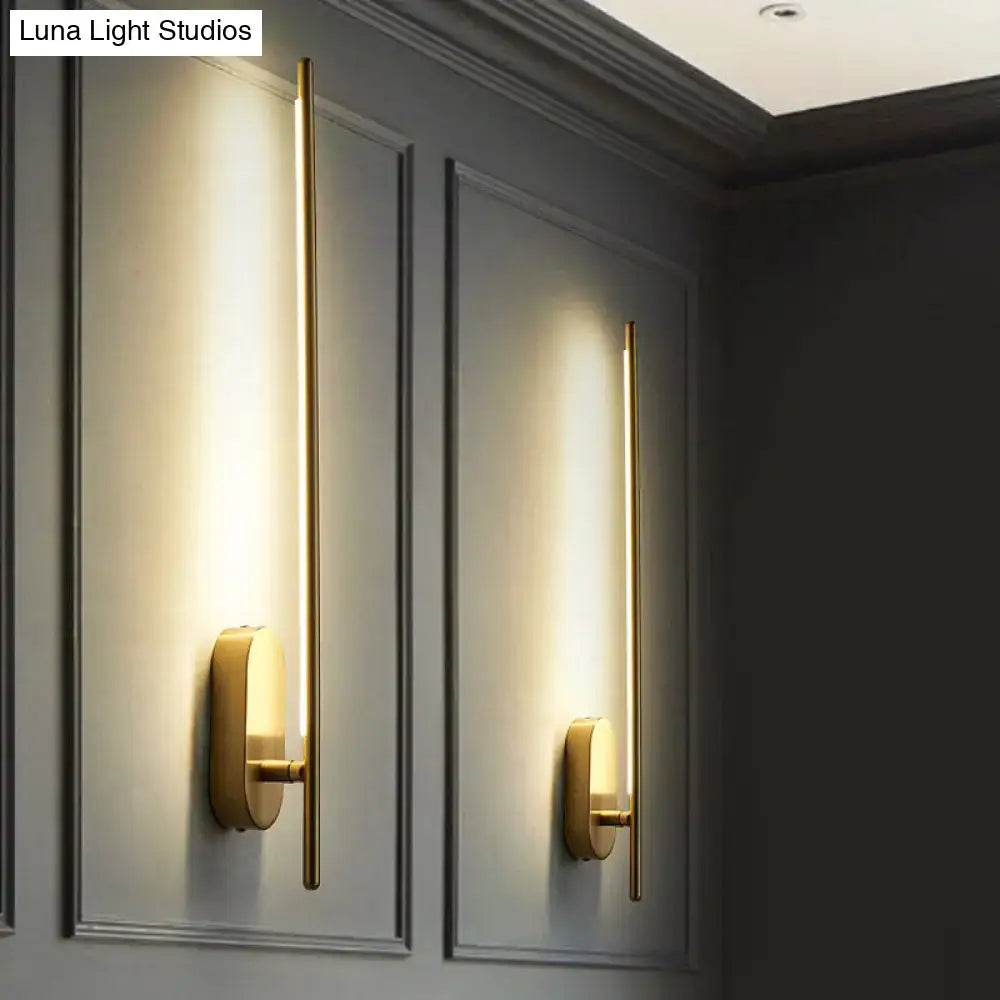 Minimalist gold-toned wall lamp with vertical rod design and oval bases offering elegant living room lighting