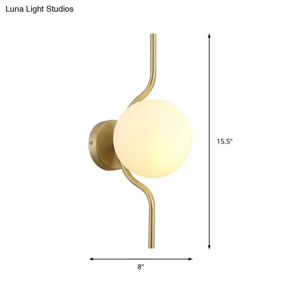 Minimalist gold wall light with a curved gold arm and frosted white globe shade for bedroom sconce light use
