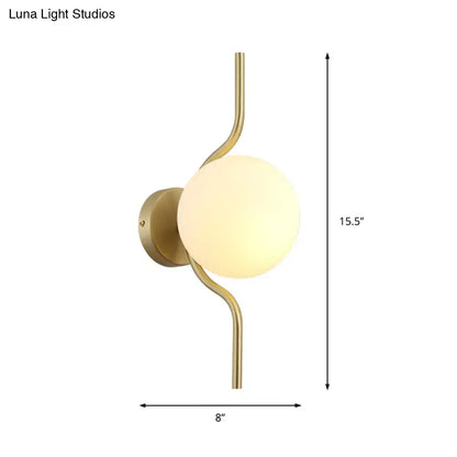 Minimalist gold wall light with a curved gold arm and frosted white globe shade for bedroom sconce light use