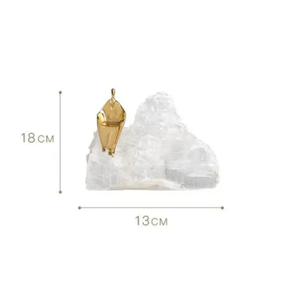 A gold-toned geometric pendant resting on a white crystal complements minimalist decorbites golden man home decor sculpture