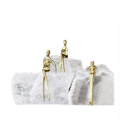 Three gold-toned minimalist golden man figurines on a white crystal base bookend for elegant home decor by decorbites