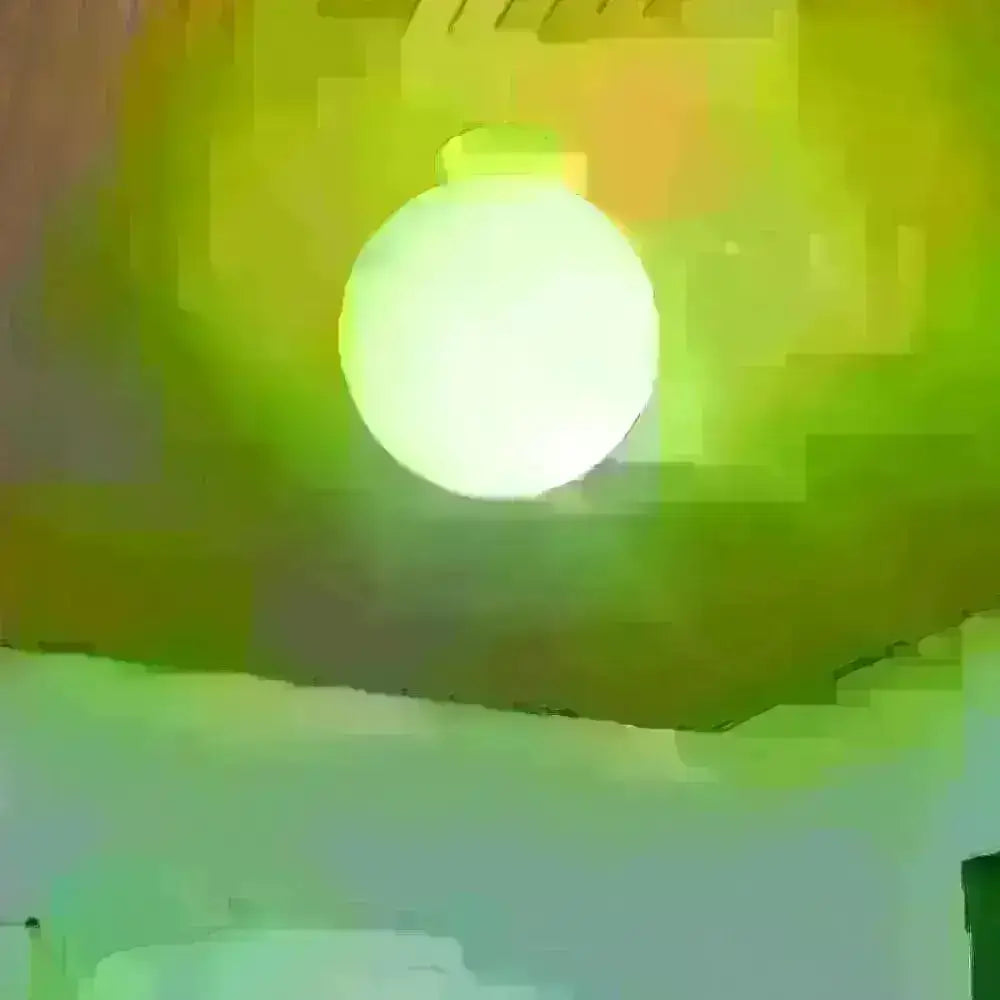 Minimalist green glass spherical sconce light with smooth translucent surface emitting soft greenish-white illumination