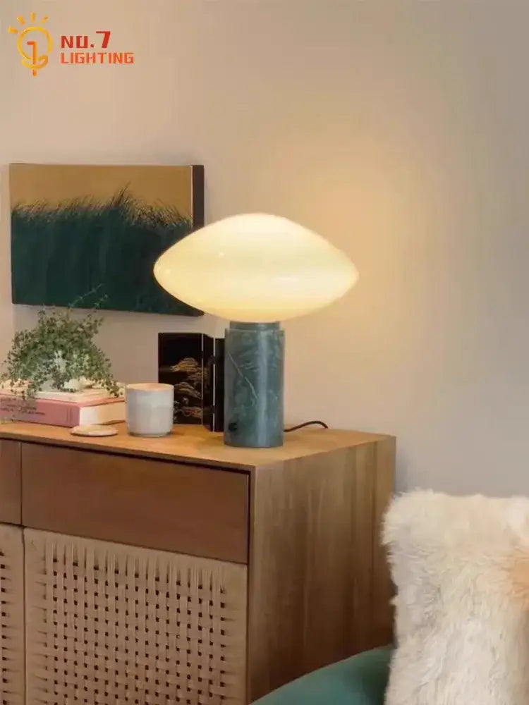 A minimalist table lamp with a frosted glass shade and textured teal base from decorbites green marble led collection