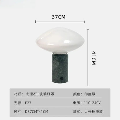 A minimalist table lamp with a glossy white glass shade and decorbites green marble led base for bedroom use