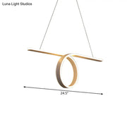 Modern gold-toned led pendant light with intersecting bar and circular ring with warm white light and fixture width details