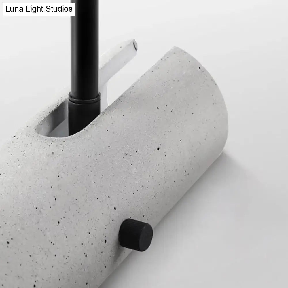 Minimalist grey led wall spotlight with concrete gray speckled cylindrical lamp base and black metal stem and knob