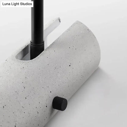 Minimalist grey led wall spotlight with concrete gray speckled cylindrical lamp base and black metal stem and knob