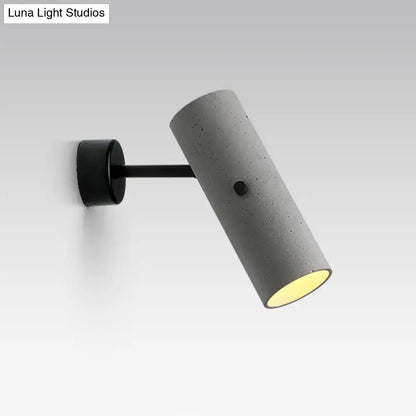 Minimalist grey led wall spotlight with a gray concrete cylindrical sconce and black mounting bracket for bedroom use