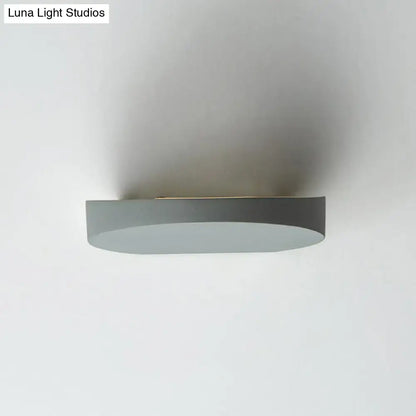 Minimalist led oval wall sconce in grey aluminum with matte finish and sleek curved design for corridor lighting