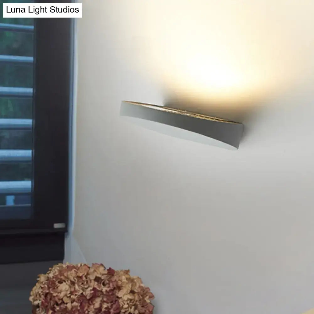 Minimalist led oval wall sconce in grey aluminum with a sleek curved design and warm ambient light bulb for corridors