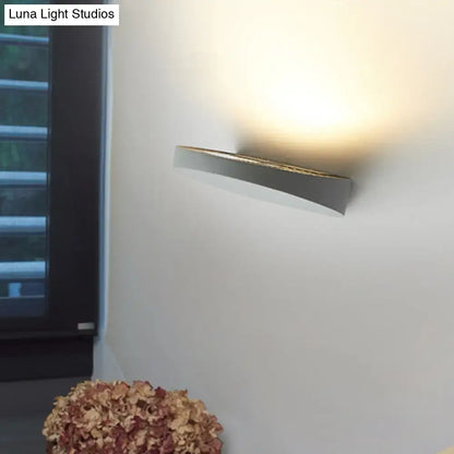 Minimalist led oval wall sconce in grey aluminum with a sleek curved design and warm ambient light bulb for corridors