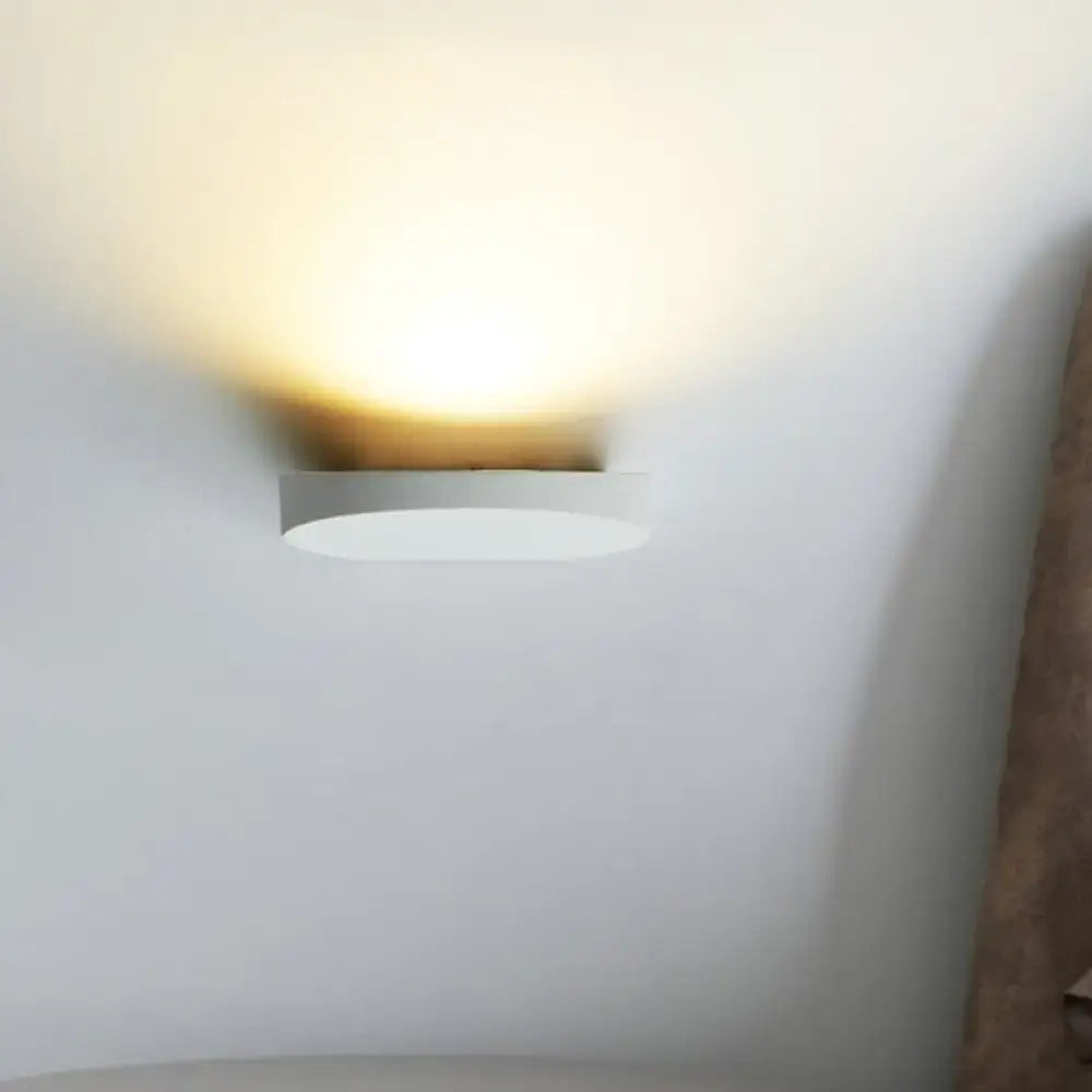 Minimalist led oval wall sconce in grey aluminum with a sleek white light bulb design for corridor lighting