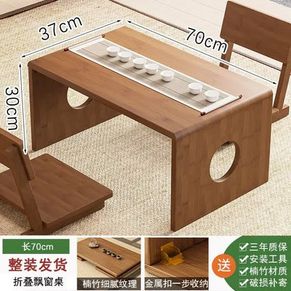 Minimalist light brown bamboo folding table with circular cutouts and built-in tray holding six white ceramic cups