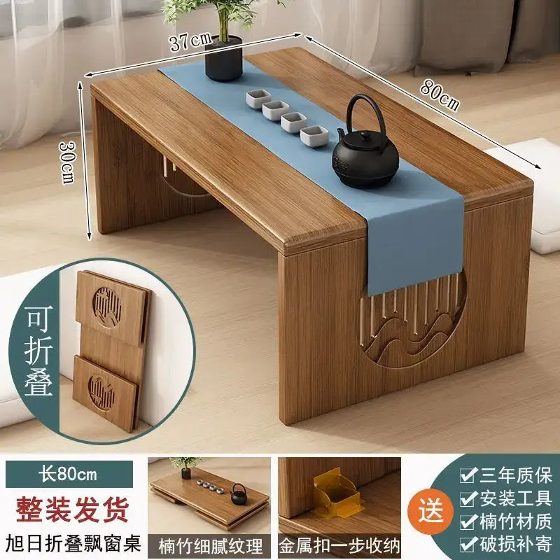 A minimalist light brown bamboo folding table with a blue runner and carved wave patterns for bedroom tea use