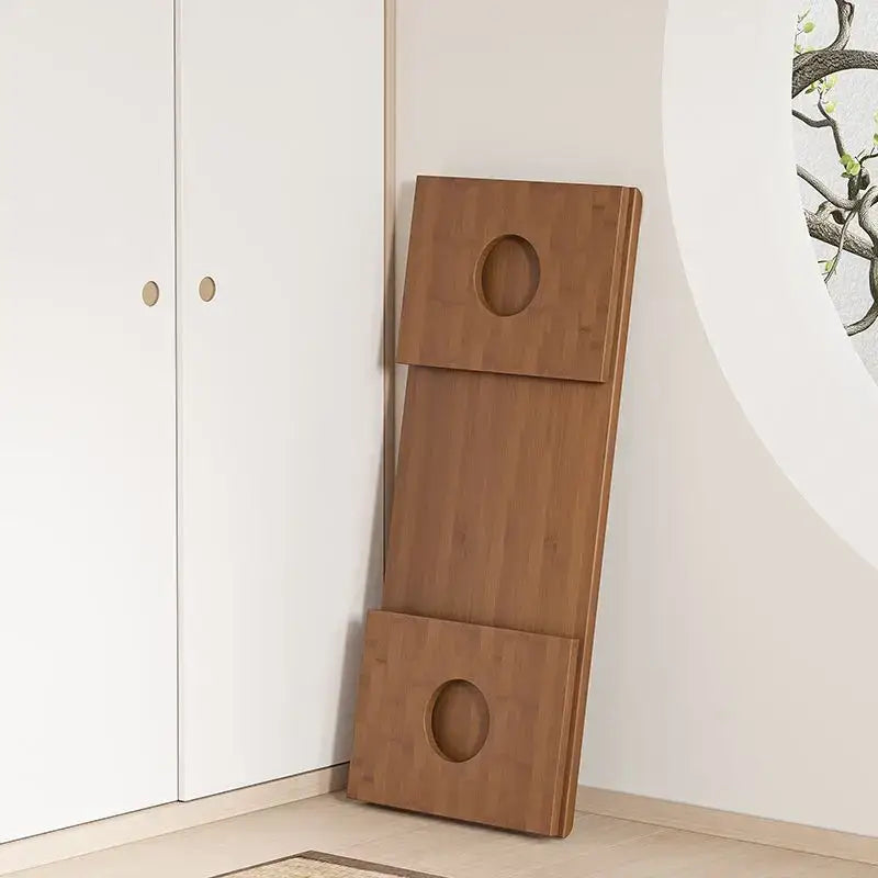 A minimalist light brown bamboo folding table with three stacked sections and oval cutouts, ideal as a bedroom tea desk