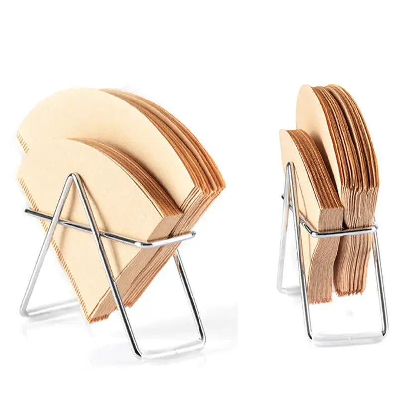 Minimalist light wood coffee filter holder with sleek chrome metal stand holding light brown cone-shaped coffee filters
