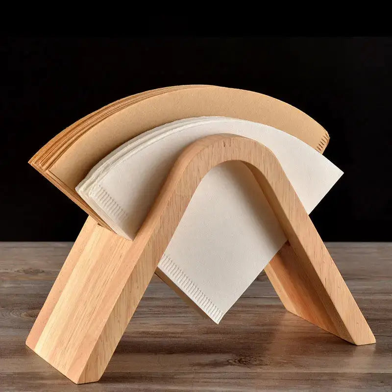 Minimalist light wood coffee filter holder with curved design holding stacked white paper towels for kitchen use