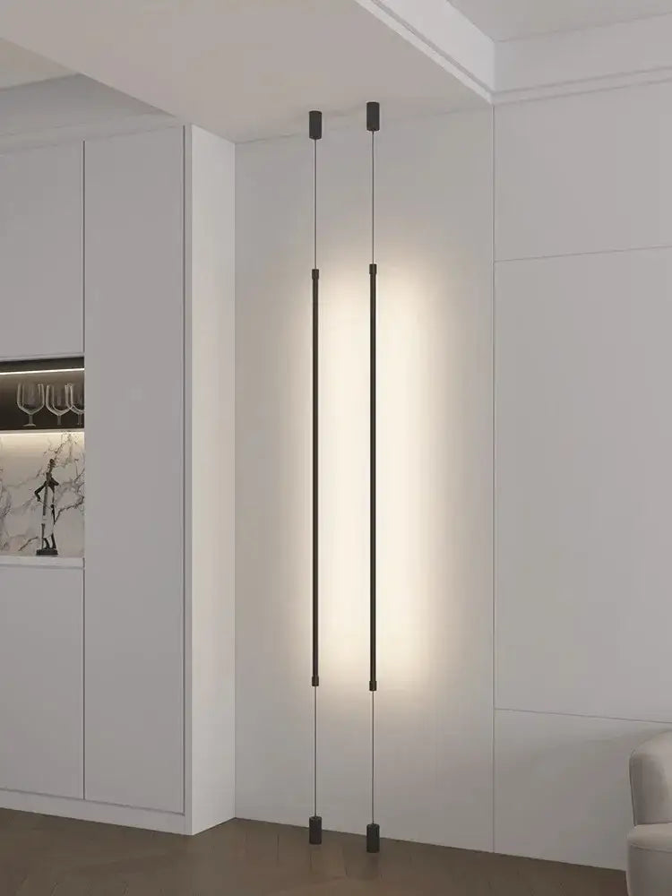 Minimalist matte black cylindrical pendant light strip with two slender rods emitting warm glow for bedroom use