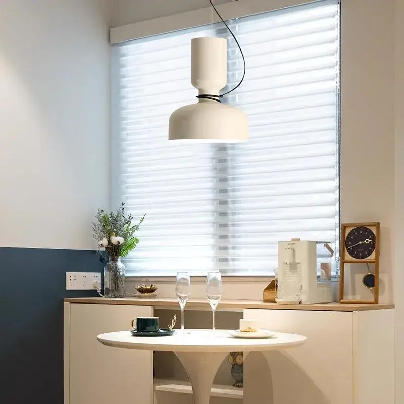 Minimalist matte black and off-white pendant light with two stacked cylinders and decorbites forged iron features