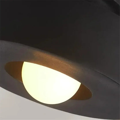 Minimalist matte black round ceiling light with warm glowing bulb and curved design by Decorbites ceiling light