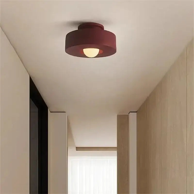 Minimalist decorbites ceiling light with a matte burgundy finish and warm glow for modern bedroom decor