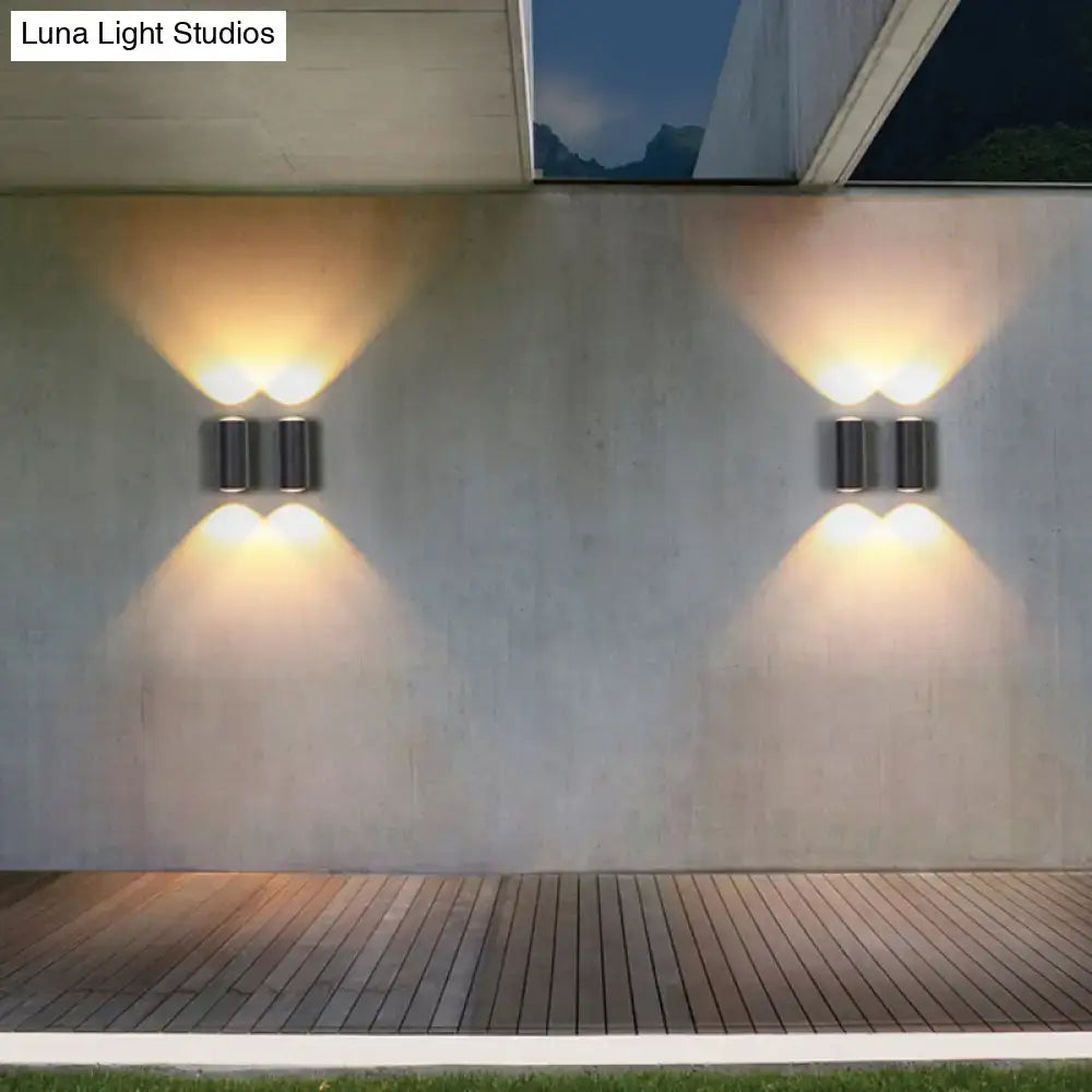 Minimalist matte black cylindrical wall light with dual warm-toned lights designed as an outdoor sconce light type