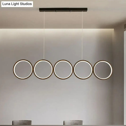 Modern black minimalist metallic led suspension lamp with five illuminated circular rings providing warm white light
