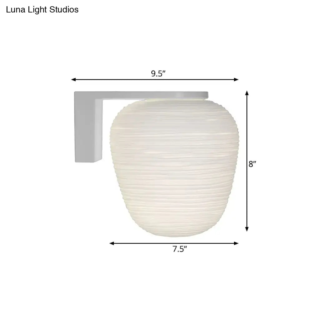 Off-white ribbed glass wall mounted lighting with milky ribbed glass and sleek gray bracket for bedroom use