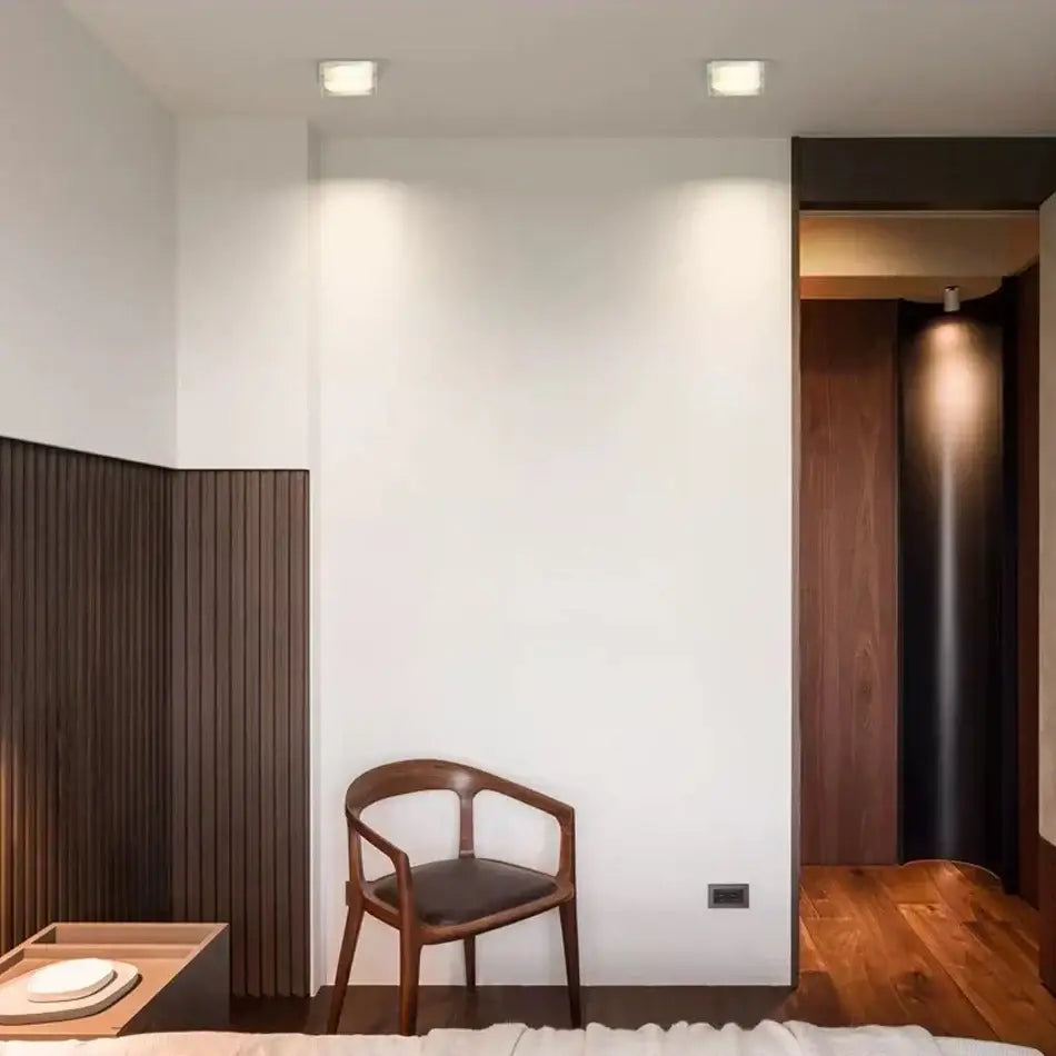 Minimalist wooden chair with dark brown frame and black leather seat under decorbites crystal dimmable led spot light
