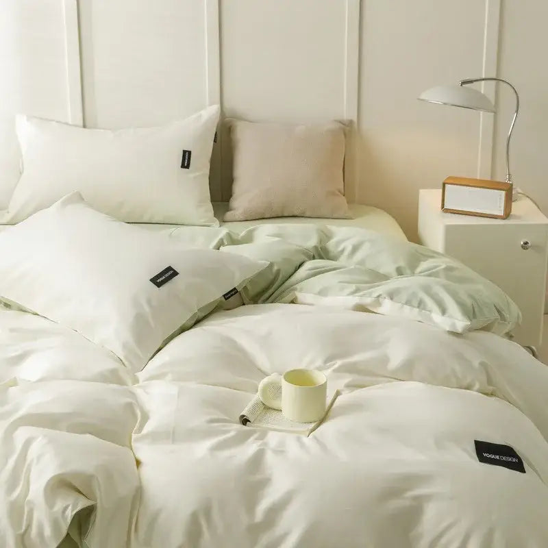 Cream-colored soft textured matching cotton bedding set with subtle sheen and black brand tags for minimalist bedroom