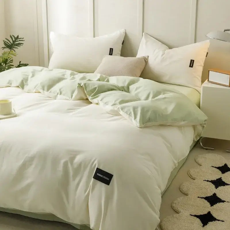 Soft mint green and off-white matching cotton bedding set with subtle texture and black brand tag on corner
