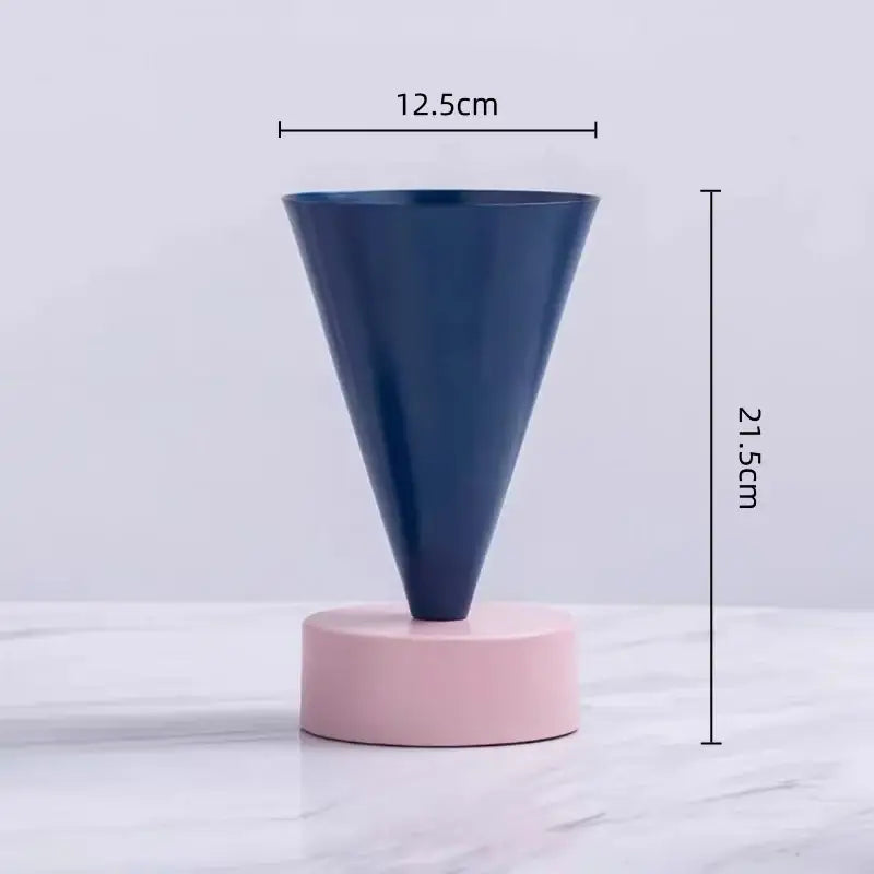 A sleek navy blue matte conical geometric triangle vase on a soft pink base for decorbites geometric triangle decor