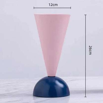 A minimalist geometric triangle vase with a matte pink cone and glossy navy blue base for living room decorbites decor