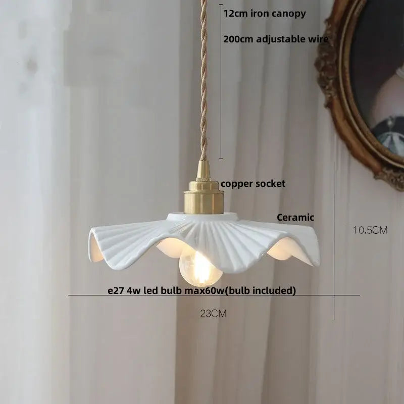 White ceramic pendant light fixture with fluted petal design and brass accents for minimalist kitchen lighting