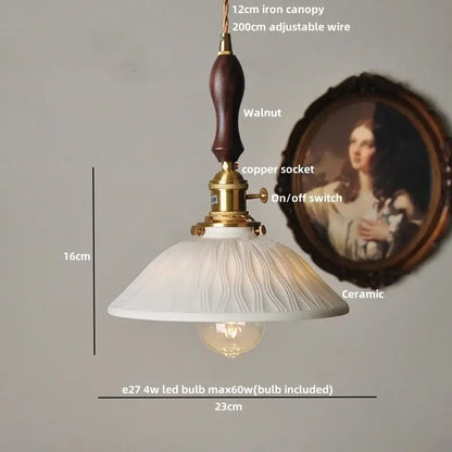 Minimalist white ceramic pendant light fixture with walnut finished iron canopy and brass accents for kitchen use