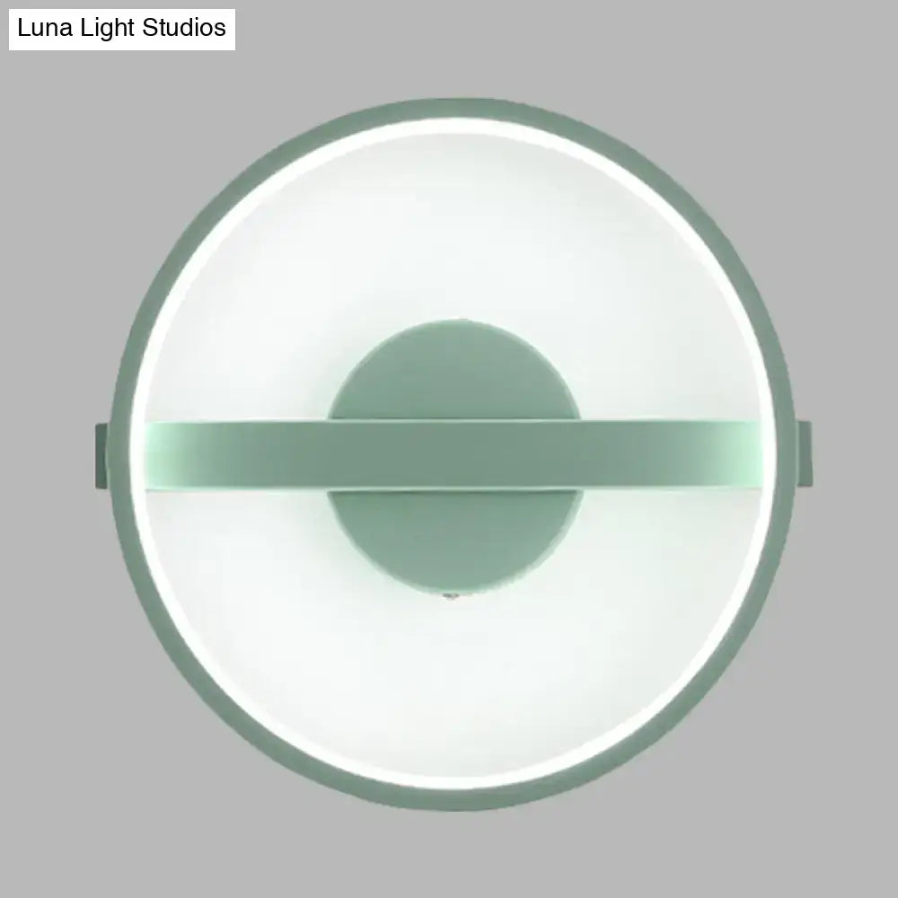 Minimalist sage green wall lamp with a matte frame and glowing white warm light LED ring for bedroom use