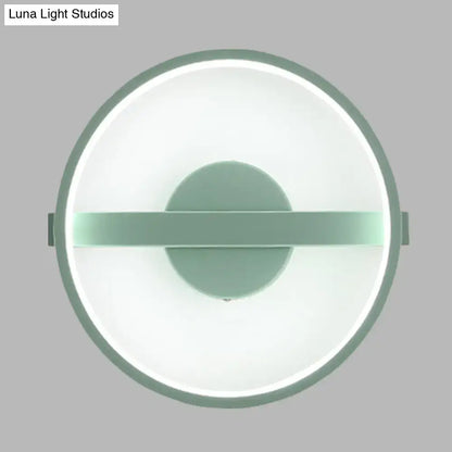 Minimalist sage green wall lamp with a matte frame and glowing white warm light LED ring for bedroom use