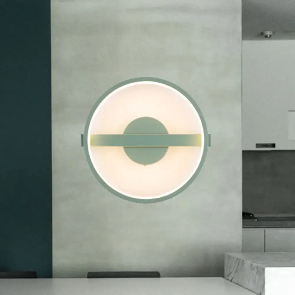 Minimalist sage green led wall lamp with a matte metal ring and soft glowing white warm light for bedroom use