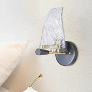 Minimalist sail glass wall light with textured translucent shade, matte black base, and brass arms for bedroom use