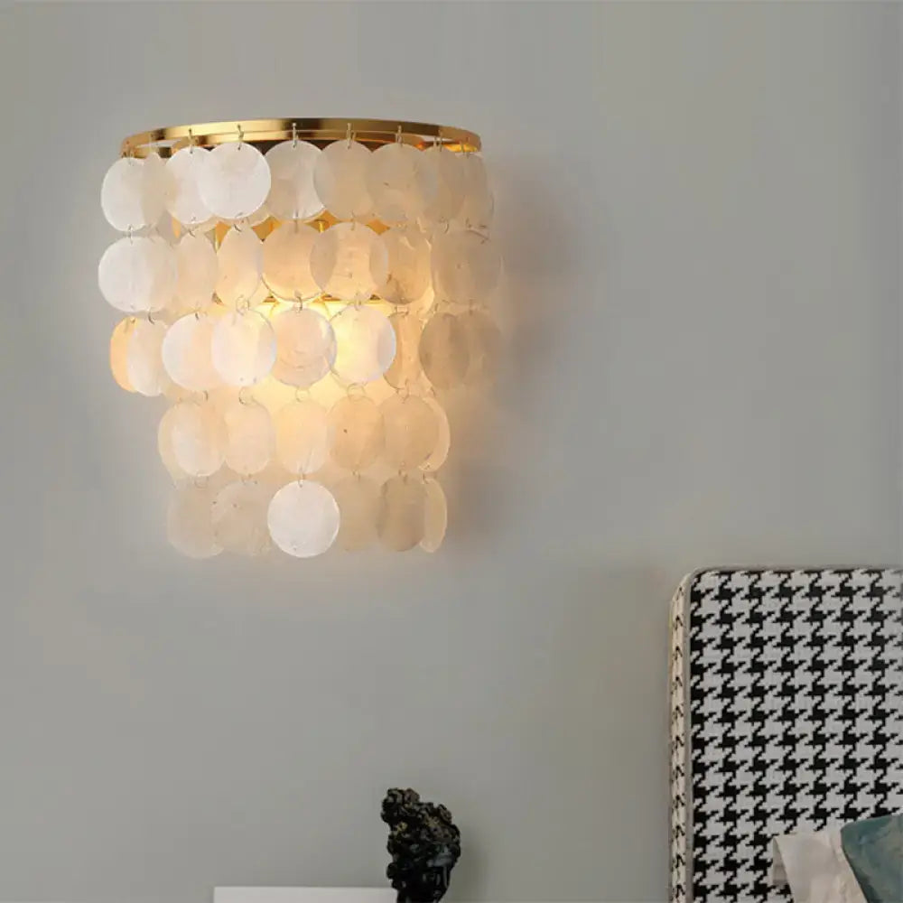 A minimalist white shell light fixture 220v-240v 110v-120v with layered translucent discs on a gold circular frame wall sconce