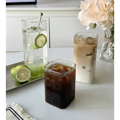 Clear square glass juice cups filled with iced beverages minimalist square glass juice cup drinkware for kitchen use