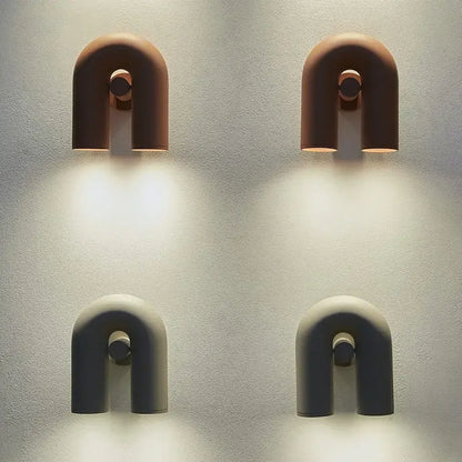 Two minimalist u-shaped cirkus tube wall sconces in terracotta and matte gray ceramic for bedroom reading light