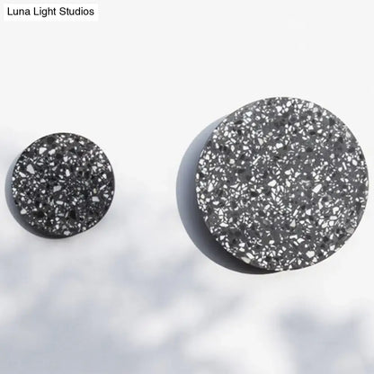Black terrazzo circular wall-mounted knobs with a speckled textured surface for minimalist terrazzo round led wall sconce bedroom light