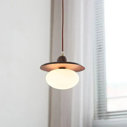 Minimalist walnut and brass glass led pendant lamp with a warm brass disc and white globe for dining room use