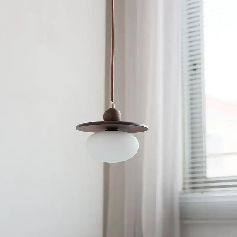 Minimalist walnut and brass glass led pendant lamp with matte white globe dark wood shade and copper cord for dining room