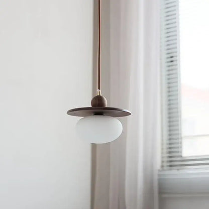 Minimalist walnut and brass glass led pendant lamp with matte white globe dark wood shade and copper cord for dining room